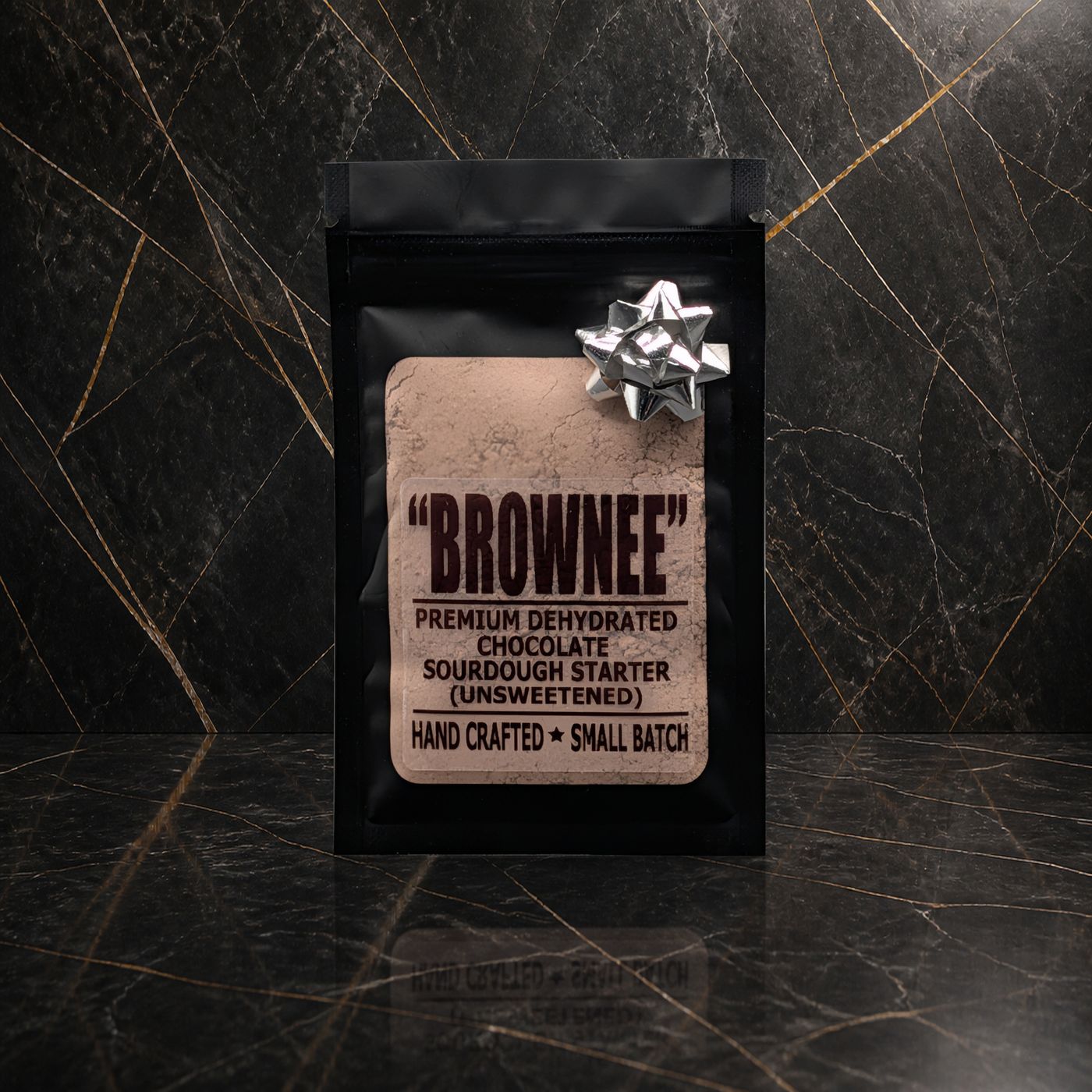 Brownee chocolate sourdough starter pouch with a silver bow on black marble